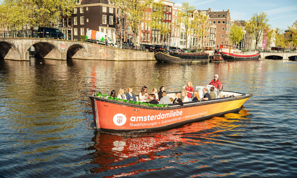 A boat on a canal in Amsterdam. People on a sightseeing tour