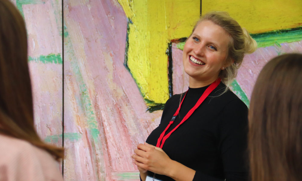 Female tour guide in Amsterdam. Smiling woman with red lanyard.