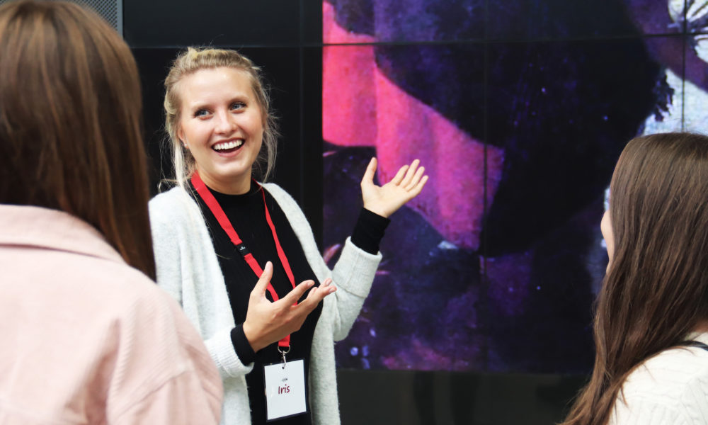 Tour guide explaining Amsterdam attractions to tourists. City trip guide.