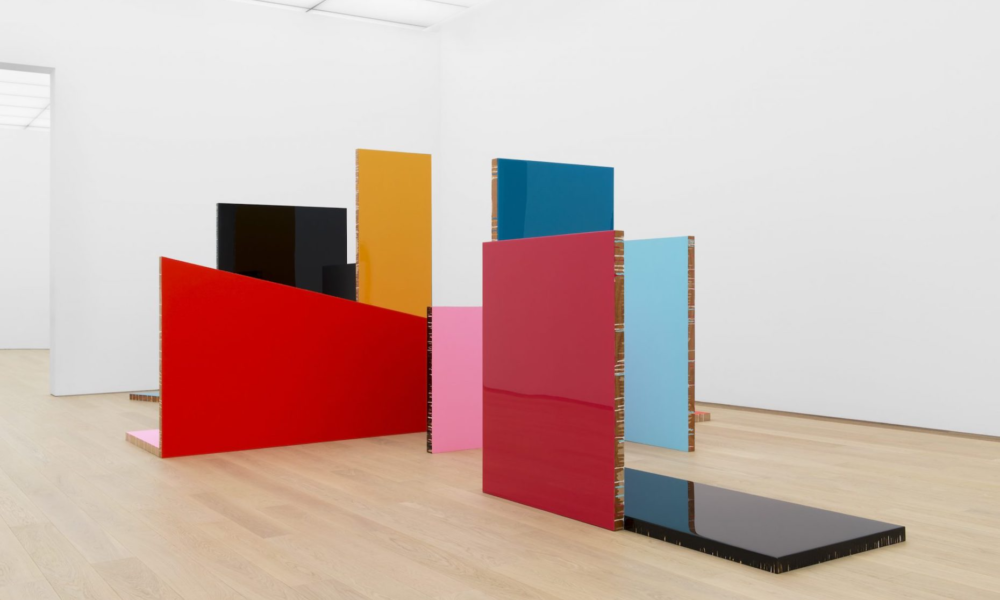 A modern art installation featuring colorful rectangular shapes. The artwork is displayed in a minimalist room.