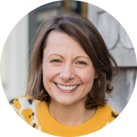 Portrait of a smiling woman with brown hair. Amsterdam city trips expert.