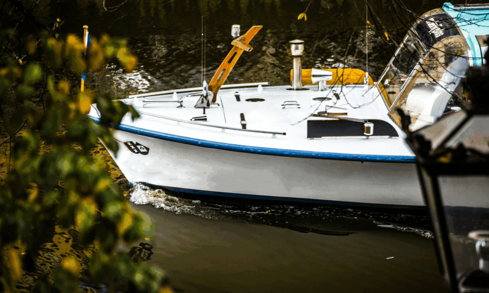 A boat on a canal in Amsterdam. The boat is floating on the water.