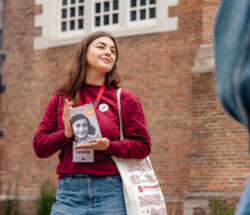 Leonie, a young tour guide from Amsterdamliebe, holding the Diary of Anne Frank during an Anne Frank Tour through Amsterdam