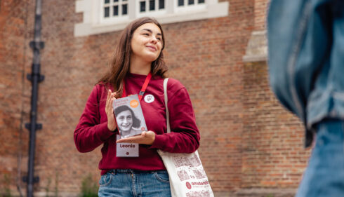 Leonie, a young tour guide from Amsterdamliebe, holding the Diary of Anne Frank during an Anne Frank Tour through Amsterdam