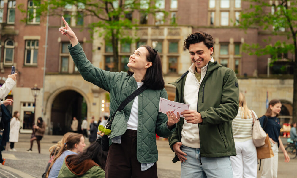 Young couple on city trip, woman holding phone and man holding map