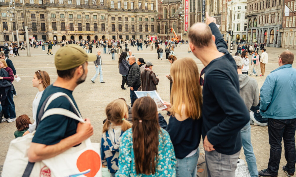 Tourists on Dam Square, Amsterdam. People exploring the city.