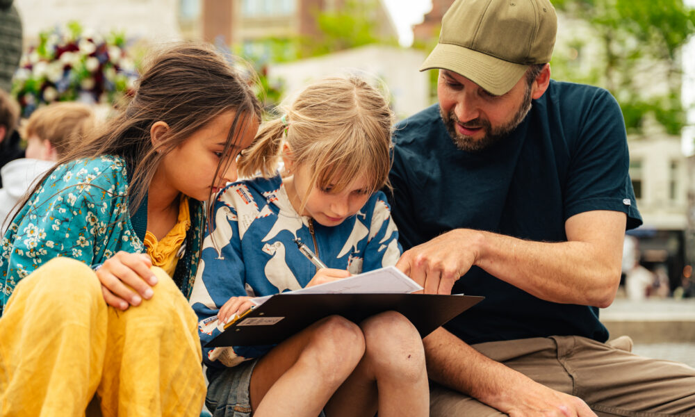 A man and two children looking at a map together