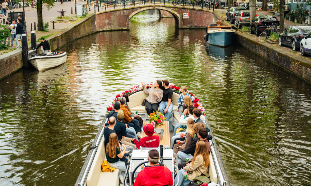 People on a boat tour in Amsterdam canal. City trip by boat.